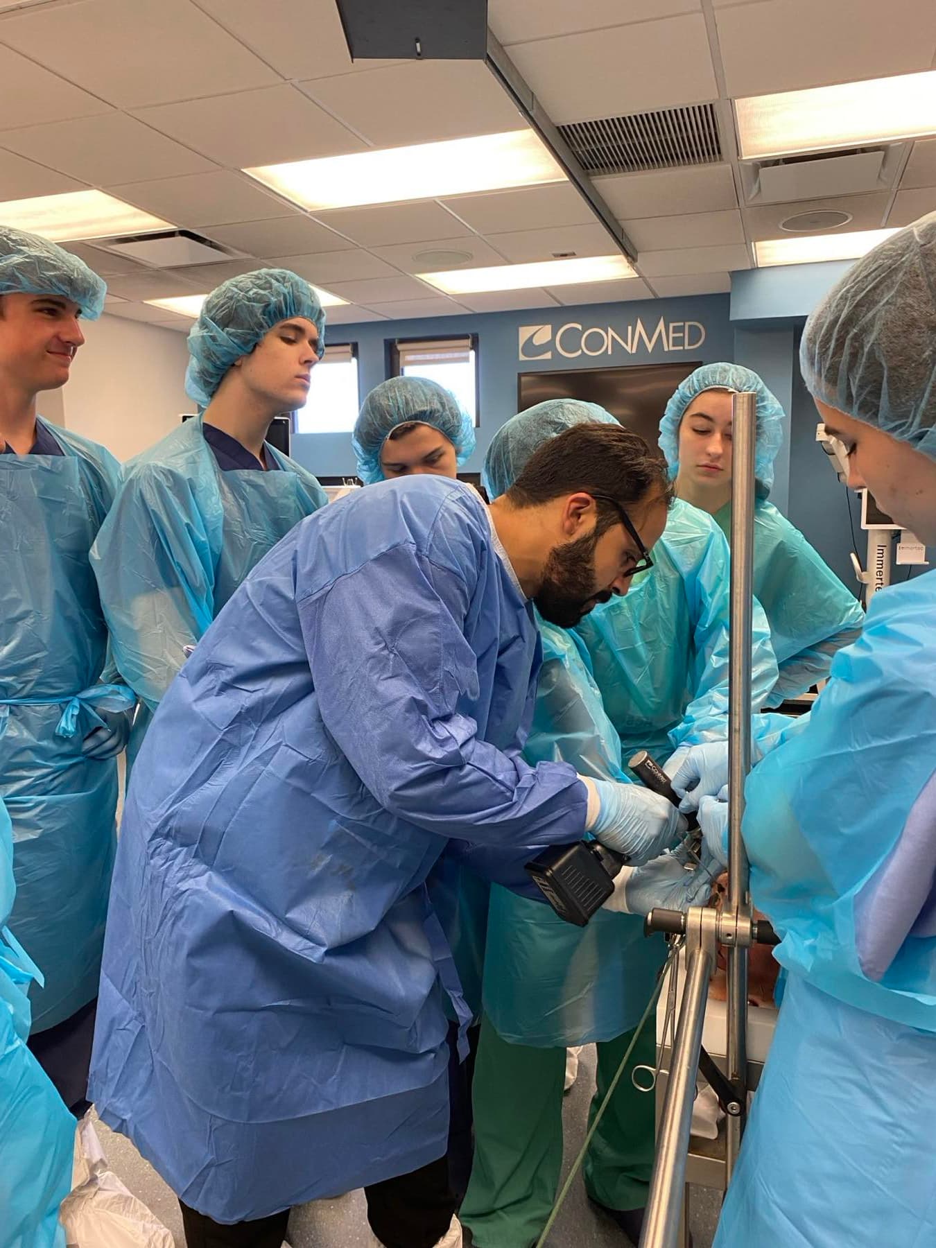 Small-group participants working side by side under direct faculty supervision.